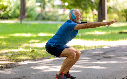 A middle-aged man doing squats for knee strengthening.