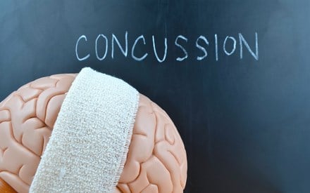 A brain with a bandage and the word concussion spelled out.