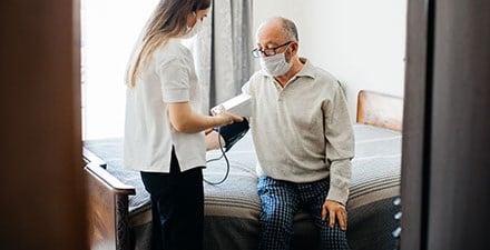 A physical therapist takes a man's blood pressure