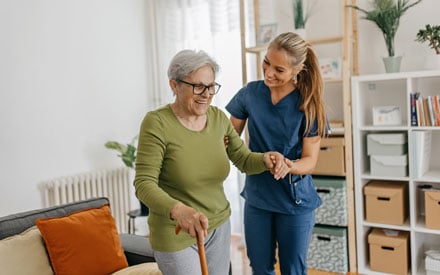 A physical therapist working with an older adult in the home.