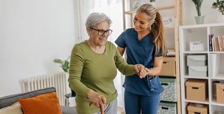 A physical therapist working with an older adult in the home.