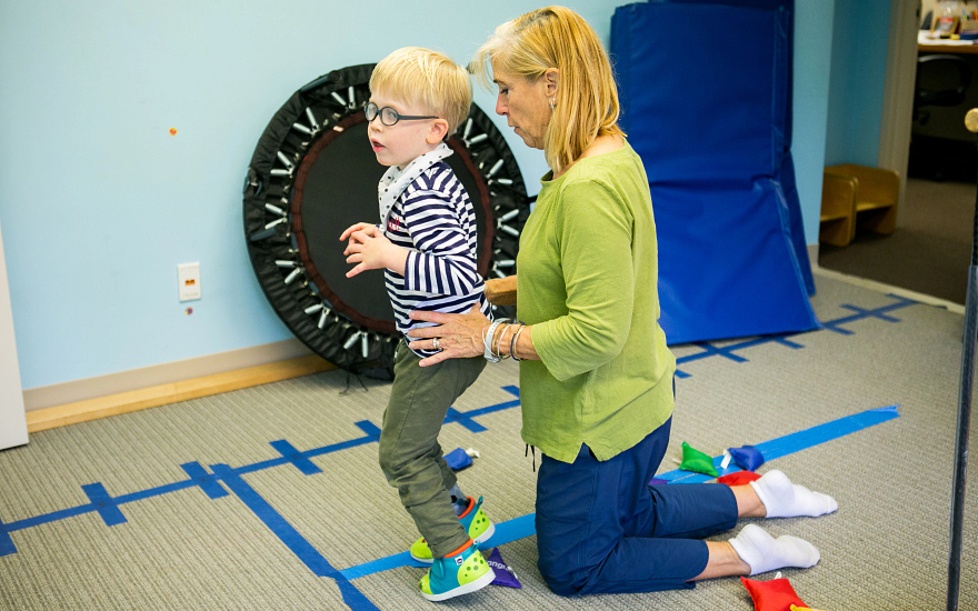 A physical therapist works with a young child.