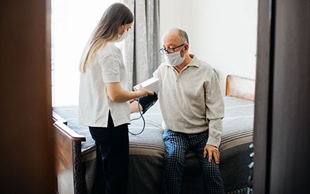 A physical therapist takes a man's blood pressure