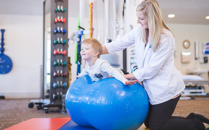 A physical therapist works with a child.