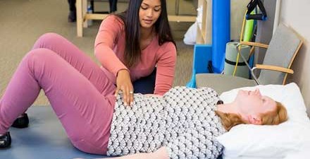 A women's health physical therapist uses hands-on therapy on a patient.