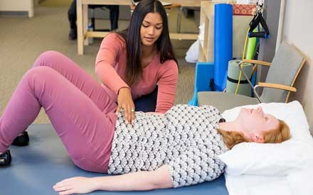 A women's health physical therapist uses hands-on therapy on a patient.