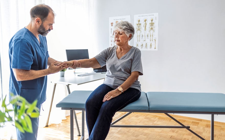 A physical therapist assess a person's wrist pain.
