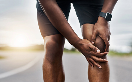 Man holding knee in pain.