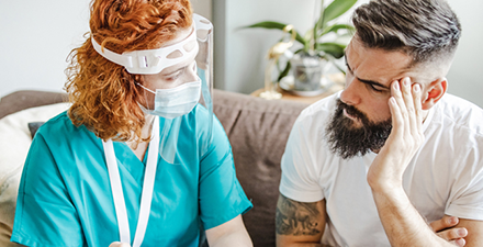 Patient and PT wearing masks discussing an issue.